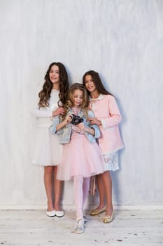 Two beautiful fashionable girls girlfriend in pink and white dresses at the photo shoot