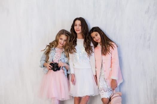 Two beautiful fashionable girls girlfriend in pink and white dresses at the photo shoot