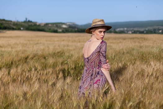 Portrait of a beautiful fashionable woman in a field before harvesting on the farm