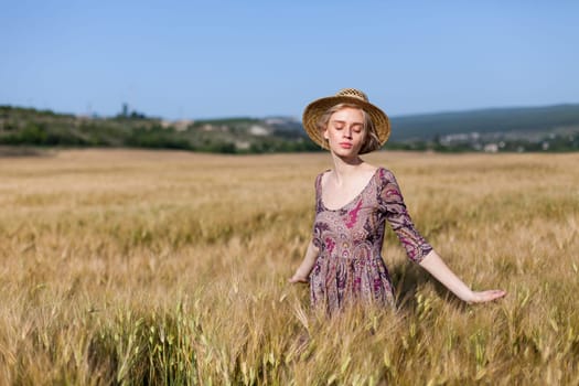 Portrait of a beautiful fashionable woman in a field before harvesting on the farm