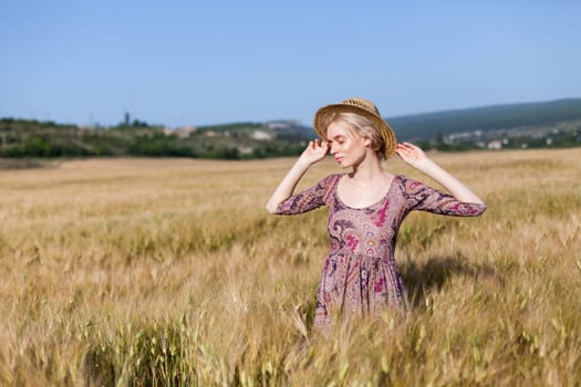 Portrait of a beautiful fashionable woman in a field before harvesting on the farm