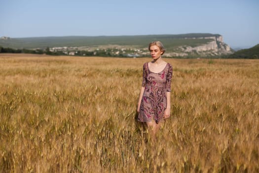 Portrait of a beautiful fashionable woman in a field before harvesting on the farm