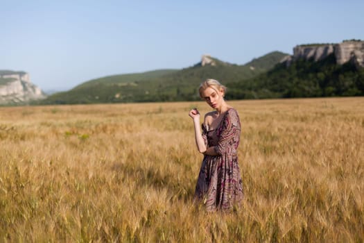 Portrait of a beautiful fashionable woman in a field before harvesting on the farm