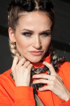 Portrait of a woman with braids in orange clothes
