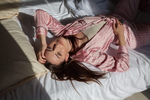 beautiful woman in pink pajamas in the bedroom