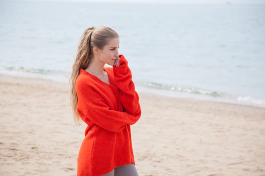 Beautiful woman walks alone on the beach by the sea