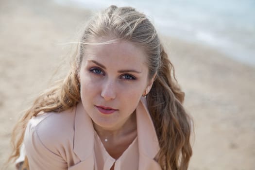 Beautiful woman walks alone on the beach by the sea