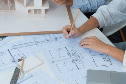 Professional engineer measures house model while skilled designer writes down in blueprint. Work together, collaboration, cooperate. Creative design and team working concept. Top view. Immaculate.