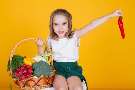 little girl holding a basket of ripe vegetables
