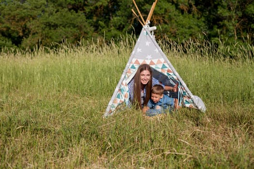 Beautiful woman with her beloved son on a picnic in the woods