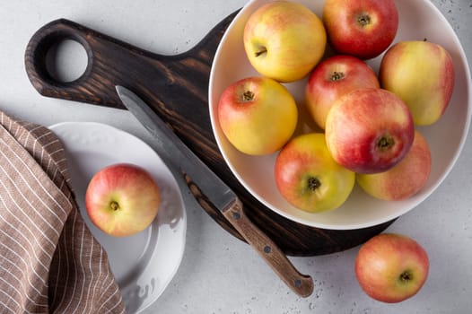 Top view of beautiful ripe apples on a plate with a knife and napkin. Selective focus.