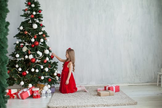 Little girl opens gifts at Christmas tree new year