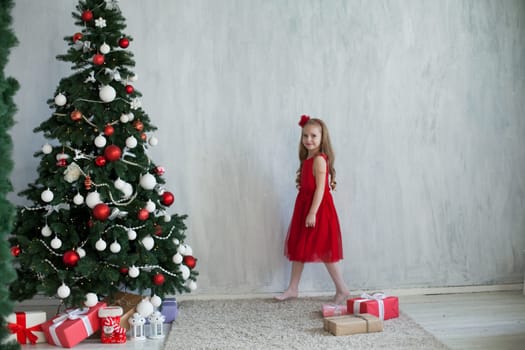 Little girl opens gifts at Christmas tree new year