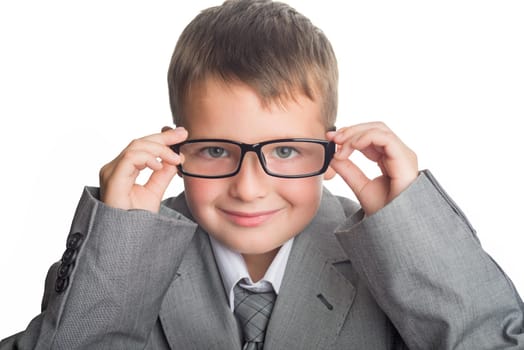 Portrait of a child dressed in a business suit and glasses as a businessman. Face of smart boy in glasses and adult suit isolated on white background.