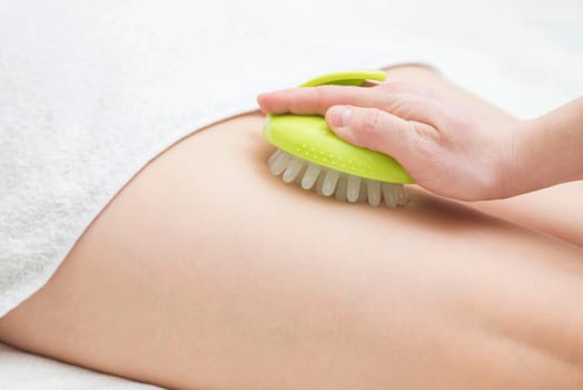 Masseur makes anticellulite massage young woman using massager. Massage with massager to prevent cellulite.