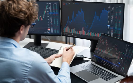 Working young business trader focusing on laptop in market stock graph data investment in real time laptop in screens. at modern office. Concept of analyzing dynamic financial exchange rate. Gusher.