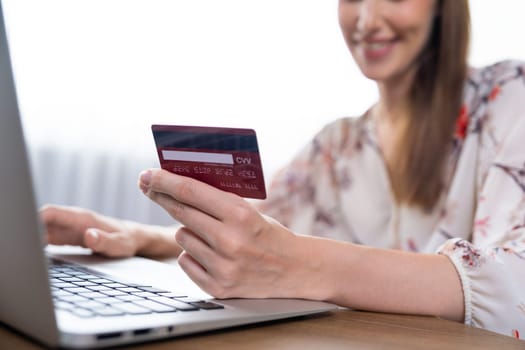 Close up credit card using for online payment, banking and shopping on the internet network with laptop computer showing credit card technology for online secured wallet top up and utmost purchase