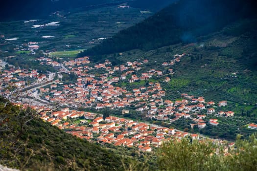 Scenic area of Leonidio, Arcadia, Greece with hills, rocks and small houses with red roofs on the coast, tourist and climbing resort.