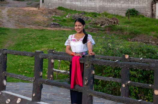 Indigenous local woman standing looking at the camera and very smiling with her traditional dress in a rural environment. High quality photo