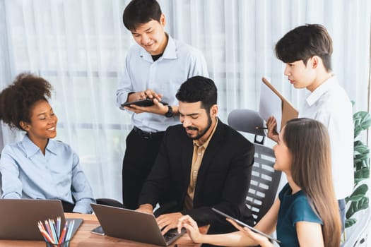 Happy diverse business people work together, discussing in corporate office. Professional and diversity teamwork discuss business plan on desk with laptop. Modern multicultural office worker. Concord