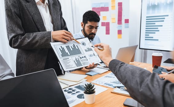 Analyst team use BI dashboard data to analyze financial report on meeting table. Group of diverse business people utilize data analysis by FIntech for business marketing decision. Concord