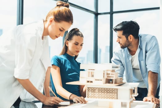 Professional diverse architect engineer team working together to design house model. Group of successful business team discussing and brainstorming about house structure. Civil engineering. Tracery.