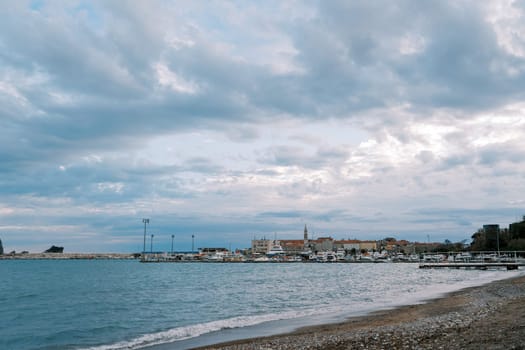Resort town with a marina on the seashore against a cloudy sky. High quality photo