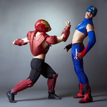 Confrontation of superheroes. Sexy male dancers in costumes