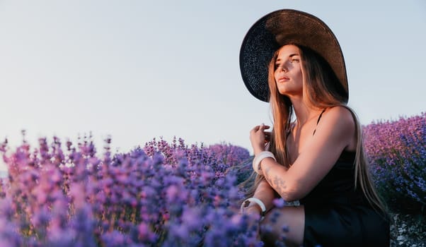 Close up portrait of young beautiful woman in a white dress and a hat is walking in the lavender field and smelling lavender bouquet.