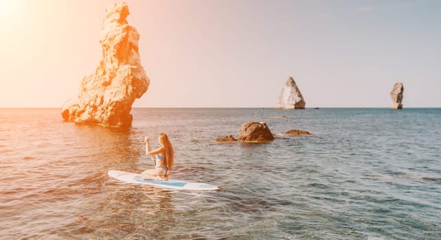 Close up shot of happy young caucasian woman looking at camera and smiling. Cute woman portrait in bikini posing on a volcanic rock high above the sea