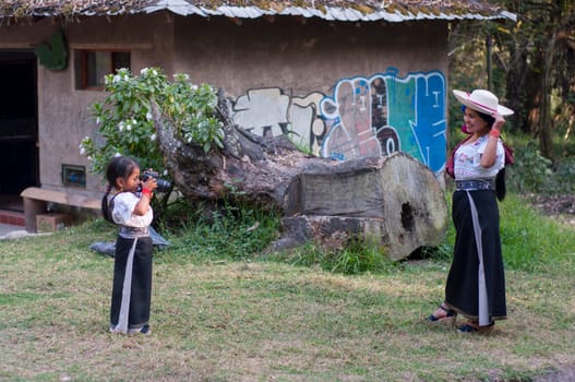 Beautiful and pleasant indigenous mother and her daughter enjoying motherhood. girl takes photos of her mother as a model of her. photography day. High quality photo