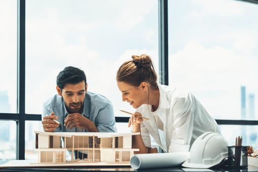 Smart caucasian architect engineer team working together to measure house model. Group of professional interior designer brainstorming and sharing ideas about design building construction. Tracery.