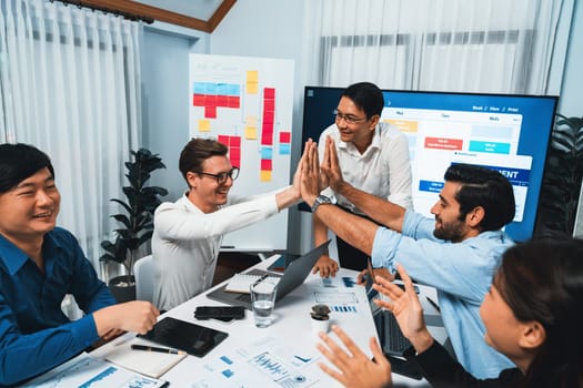 Happy office worker and project manager celebrate in meeting room after successfully achieving business task on time and on schedule. Project management tracking software for business success. Prudent