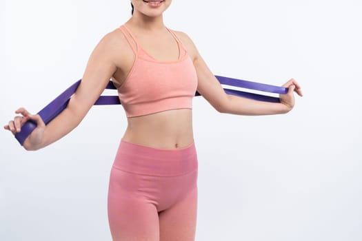 Vigorous energetic woman in sportswear portrait stretching resistance sport band. Young athletic asian woman strength and endurance training session workout routine concept on isolated background.