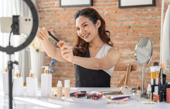 Woman influencer shoot live streaming vlog video review makeup uttermost social media or blog. Happy young girl with cosmetics studio lighting for marketing recording session broadcasting online.