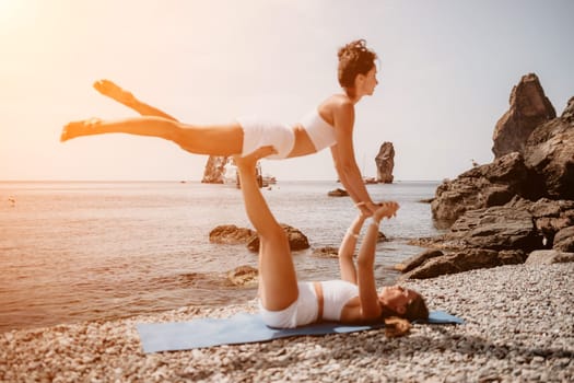 Woman sea yoga. Back view of free calm happy satisfied woman with long hair standing on top rock with yoga position against of sky by the sea. Healthy lifestyle outdoors in nature, fitness concept.