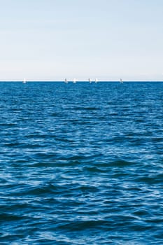 group of sailing boats on Issyk-Kul lake in Kyrgyzstan at sunny autumn afternoon