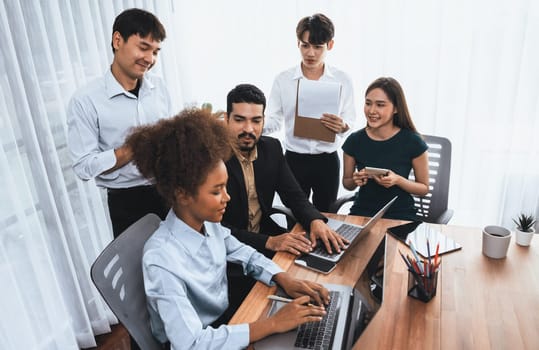 Happy diverse business people work together, discussing in corporate office. Professional and diversity teamwork discuss business plan on desk with laptop. Modern multicultural office worker. Concord