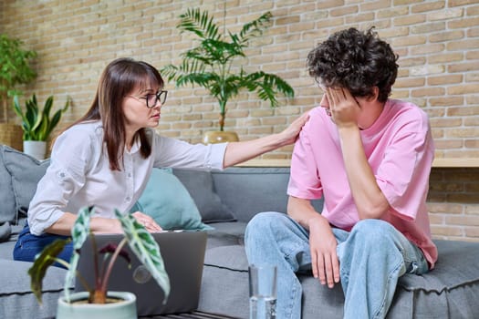 Female psychologist therapist psychotherapist counselor working with young sad stressed guy sitting on sofa in office. Psychology, psychotherapy, treatment, support, mental health of youth concept