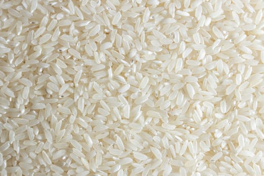 Dry Uncooked White Rice Background - Top View, Flat Lay. Scattered Raw Long Grain Rice. Asian Cuisine and Culture. Healthy Eating Ingredients. Diet Food