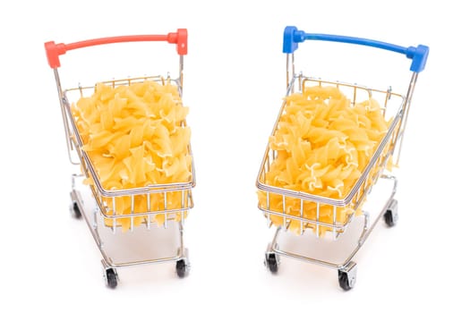 Uncooked Fusilli Pasta in Two Small Shopping Carts Isolated on White Background. A Crisis: Buying Cheap Food. Classic Dry Spiral Macaroni. Italian Culture and Cuisine. Raw Pasta - Isolation