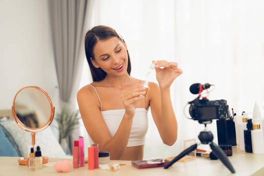 Young woman making beauty and cosmetic tutorial video content for social media. Beauty blogger smiles to camera while showing how to beauty care to audience or followers. Unveiling