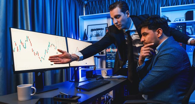 Stock exchange traders looking on high profit chart investment in panorama view, analyzing on monitor at night. Concept of discussing financial technology growth in neon light at workplace. Sellable.