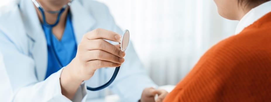 Patient attend doctor's appointment at clinic or hospital office. Doctor examining and diagnosis symptoms while checking the patient's pulse with stethoscope. Panorama Rigid