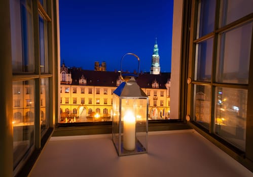 Lamp with a candle in the window. View of the market square