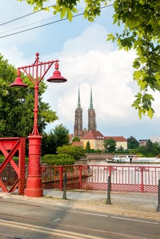 Wroclaw Poland. Red street lamps on Sand Bridge. View to cathedral of Saint John the Baptist on Tumski island.