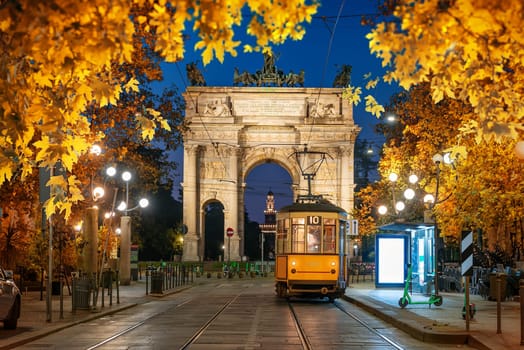 View of the Peace Arch with yellow tram in Milan, Italy