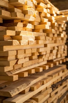 Stacked wooden planks in close-up at lumber warehouse. Air-drying timber stack. Wood air drying. Wood for house construction. Wood industry