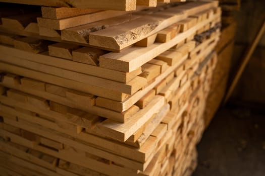 Stacked wooden planks in close-up at a outdoor lumber warehouse. Background of boards. Wood industry