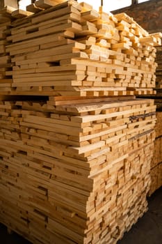 Stacked wooden planks. Hardware store or construction site. Wood for house construction. Building material. Wood warehouse. Wood industry